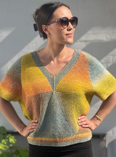 Hexa Sommer – T-shirt i bomuld med korte ærmer og modulstrikkede trekanter i gule, orange og grønne nuancer.